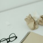 机の上のノートとメガネ。少額訴訟は書類を揃えて臨む手続き