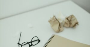机の上のノートとメガネ。少額訴訟は書類を揃えて臨む手続き