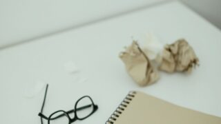 60万円以下の未払いに少額訴訟は使える?1回で終わる条件と避けるべきケース 15 机の上のノートとメガネ。少額訴訟は書類を揃えて臨む手続き