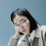 職場で頬杖をつき疲れた表情の女性